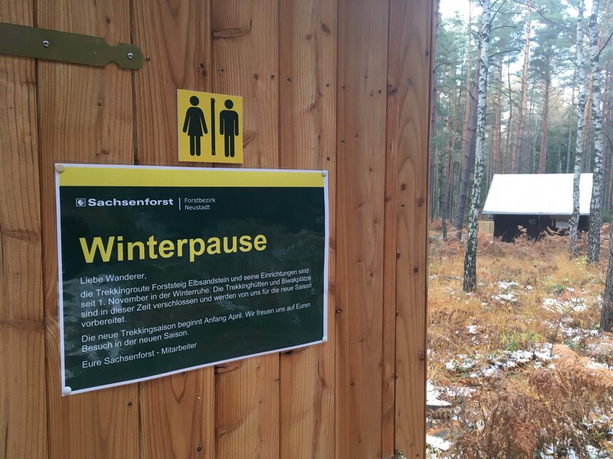 Toilettentür mit Hinweisschild zur Winterpause am Forststeig