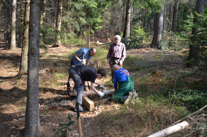 Menschen arbeiten an einem Holzsteg