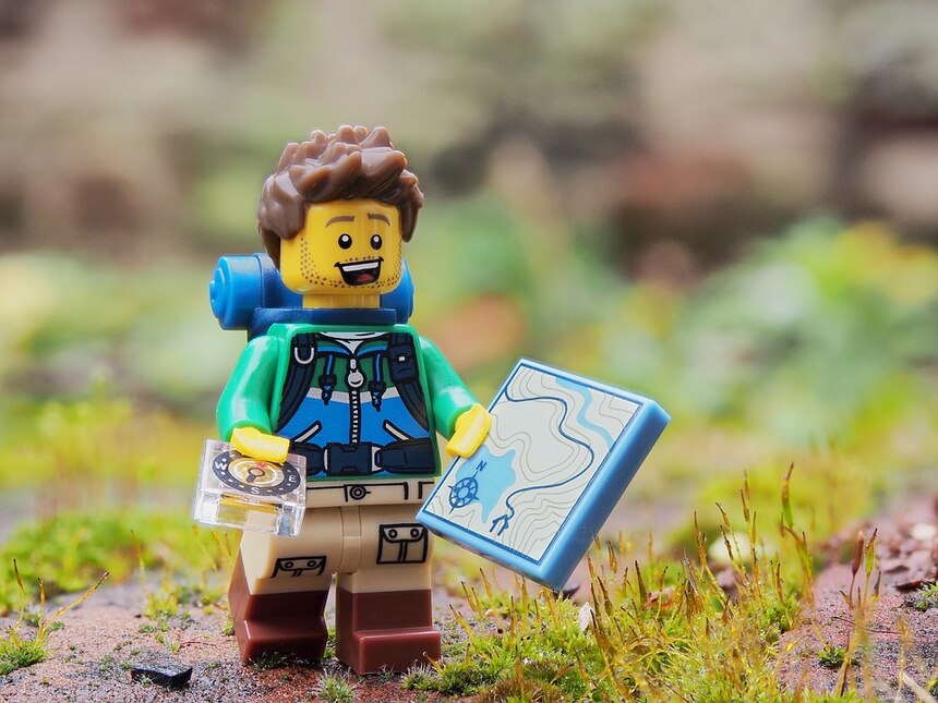 Lego Figur mit Karte und Kompass